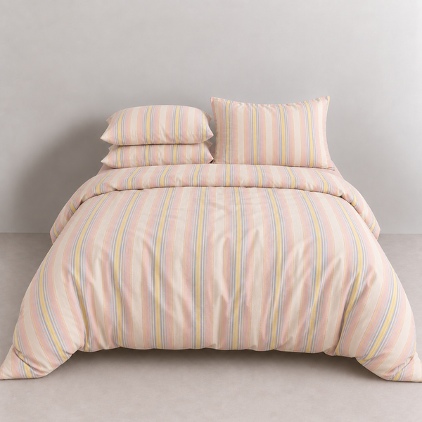 Soleil Stripe Bedding Set in Butter Stripe, made bed with pink, yellow and blue cotton stripes