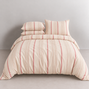 Soleil Stripe Bedding Set in Caramel Clay, made bed with pink and cream vertical stripes