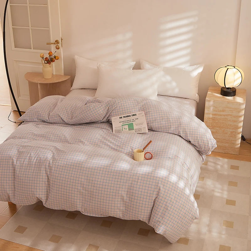 Soleil Stripe Bedding Set in Champagne Mist, soft grey-pink check on a sunlit bed with white pillowcases