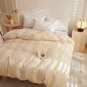 Soleil Stripe Bedding Set in Lemon Cream, yarn-dyed stripes on a made bed with white pillows and warm light