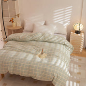 Soleil Stripe Bedding Set in Moss Horizon on a sunlit bed, soft green and yellow check-woven cotton with white pillowcases