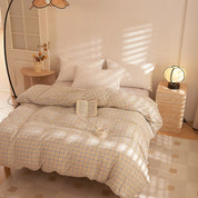 Soleil Stripe Bedding Set in Oat Milk, yellow-check quilt cover styled on a sunlit bed with a book and cup