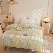 Soleil Stripe Bedding Set in Sage Linen, soft green-and-yellow check on a sunlit made bed with white pillows