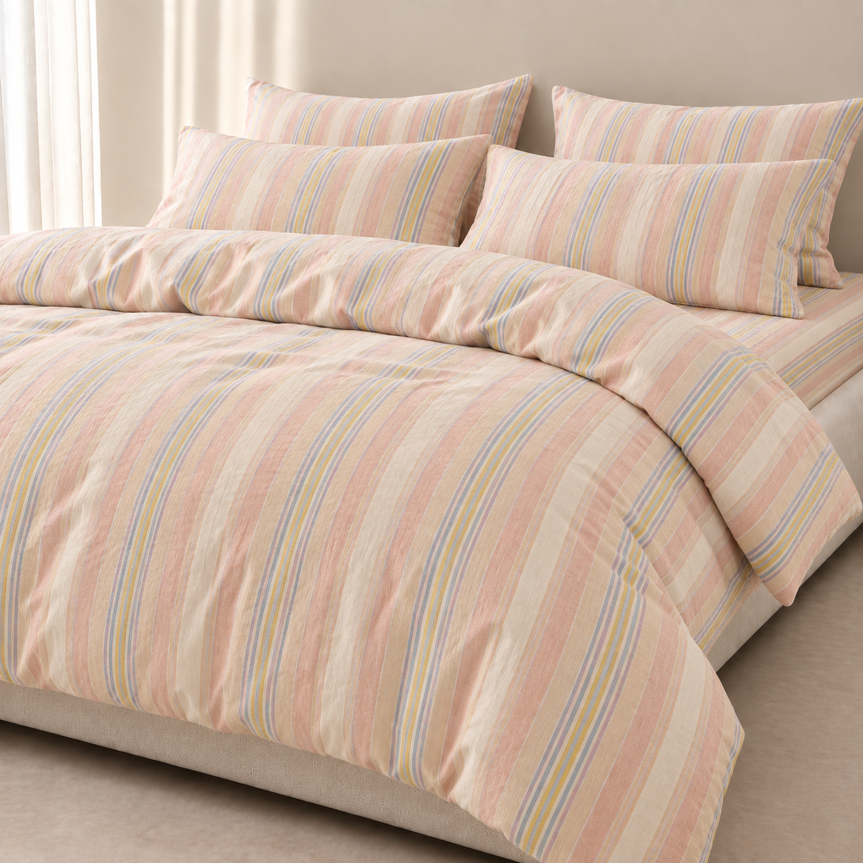 Soleil Stripe Bedding Set on a made bed, yarn-dyed stripes in blush, blue and yellow on cotton