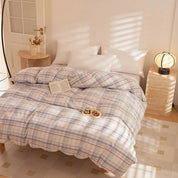 Soleil Stripe Bedding Set in soft pastel check on a sunlit bed, styled with a book and snack tray