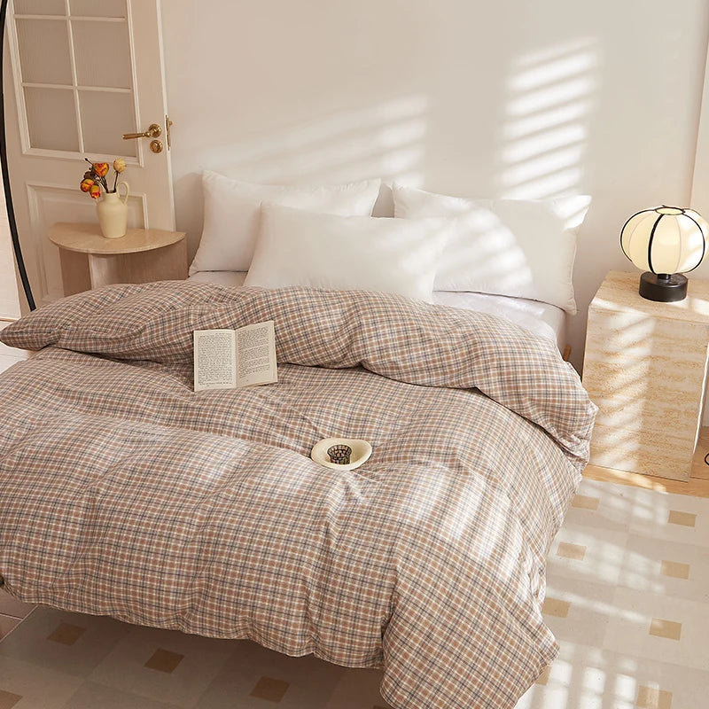 Soleil Stripe Bedding Set on a sunlit made bed, tan and cream check pattern with white pillows and an open book