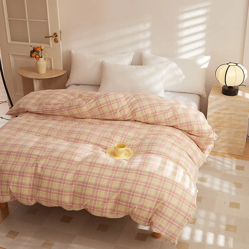 Soleil Stripe Bedding Set in Toasted Blush, pink-yellow check quilt on a sunlit bed with a teacup
