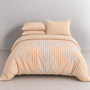 Soleil Stripe Bedding Set in Warm Amber, made bed with striped quilt cover and stacked pillowcases