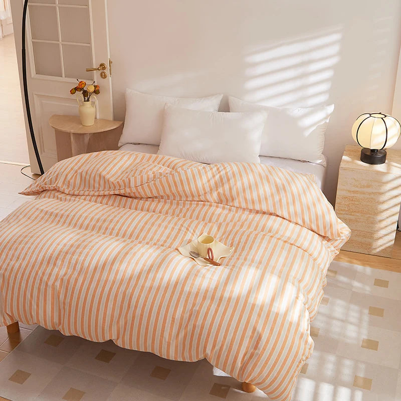 Soleil Stripe Bedding Set in Warm Amber on a sunlit bed, striped quilt cover with white pillows behind