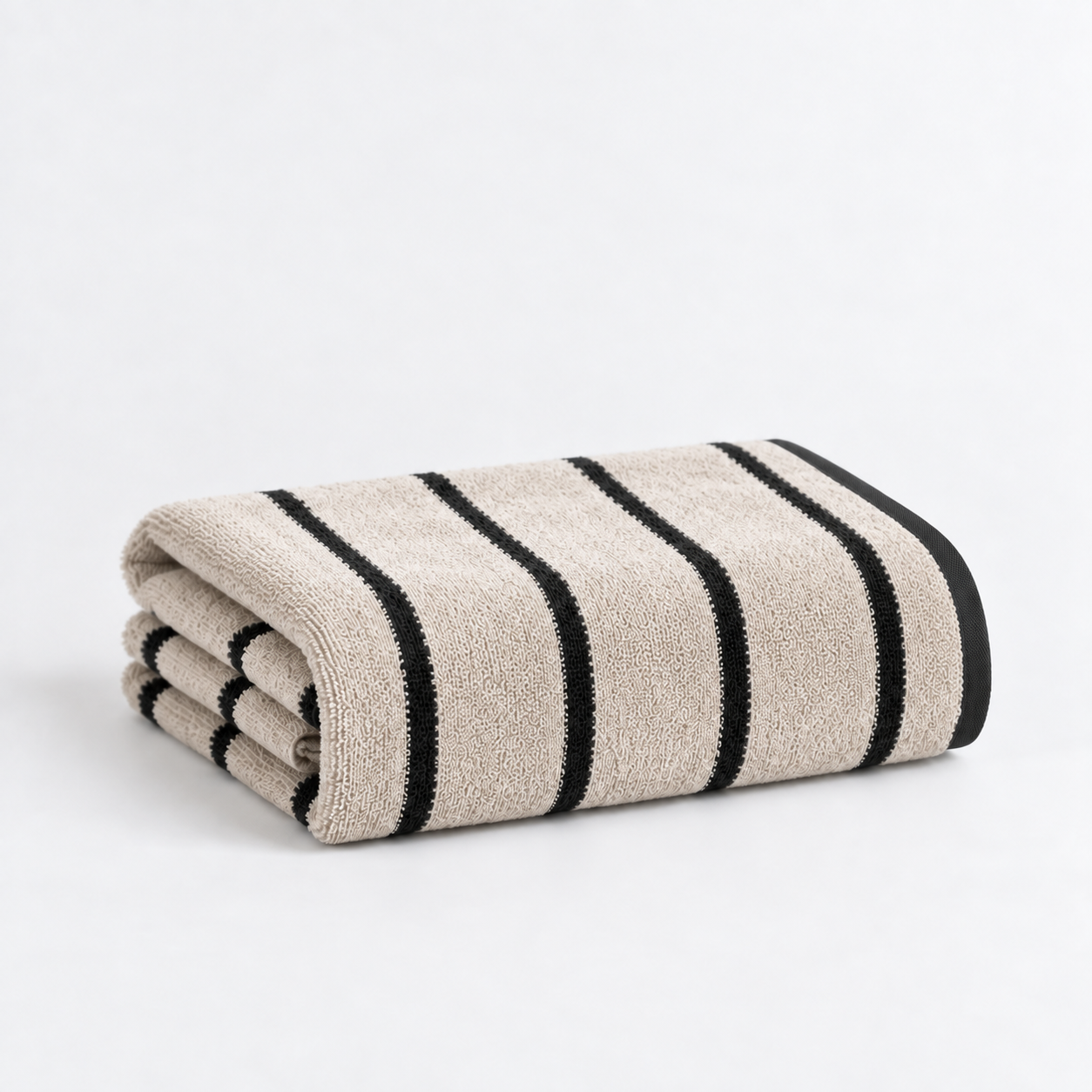 Folded bath towel from the Stay Soft™ Neutral Towel Collection in Beige, with contrast black stripes