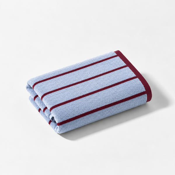 Folded hand towel from the Stay Soft™ Neutral Towel Collection in Blue, with contrast maroon stripe edge