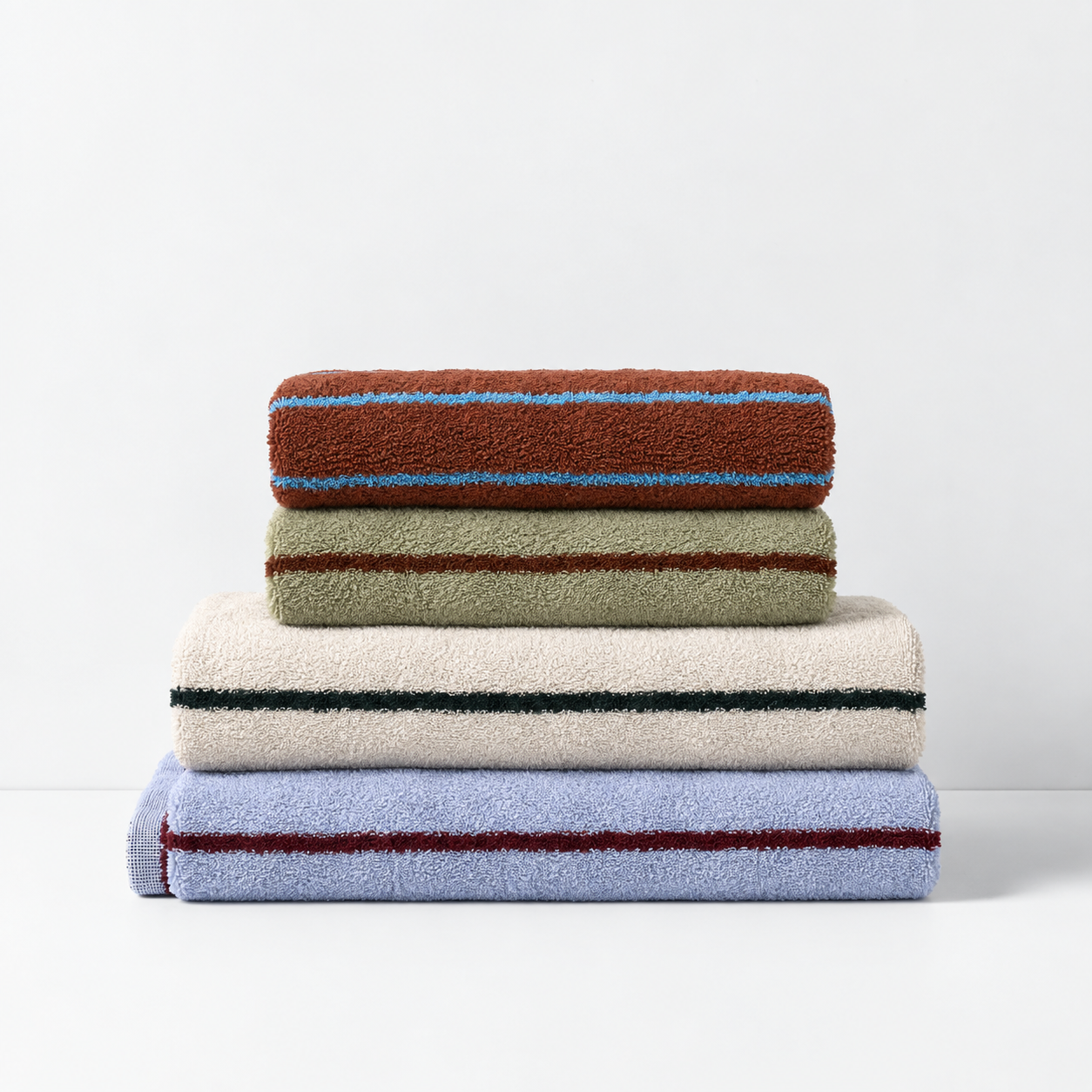 Stay Soft™ Neutral Towel Collection folded stack in brown, green, beige and blue, each with a contrast stripe