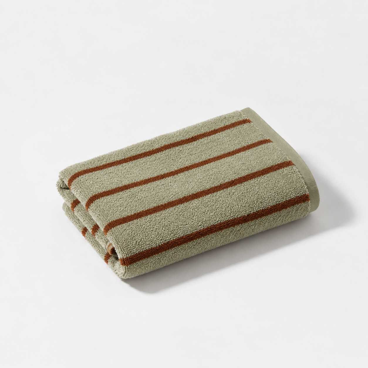 Folded hand towel from the Stay Soft™ Neutral Towel Collection in Green, with rust stripe detail