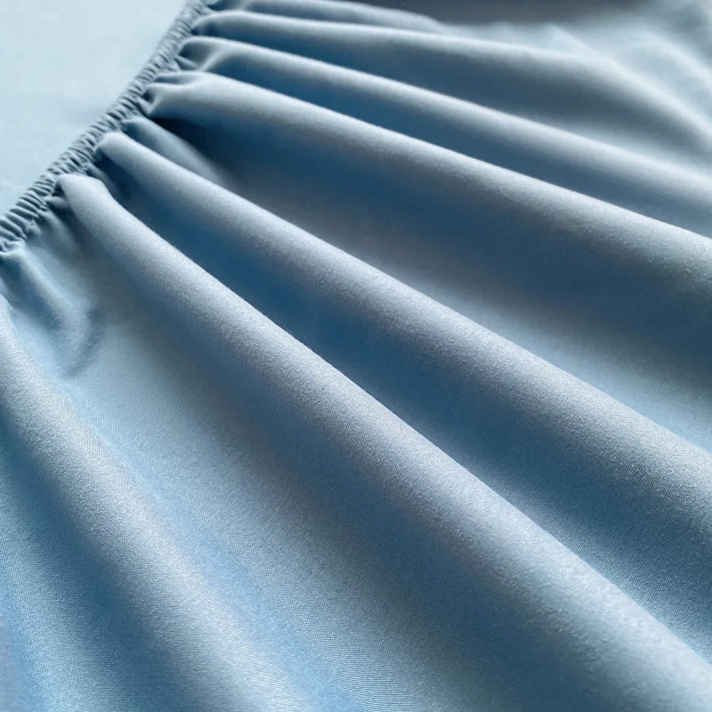 Close-up of the Tate Fitted Sheet's elasticised edge, pale blue twill weave gathered and smooth