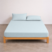 Tate Fitted Sheet in pale blue-grey on a timber bed frame, fitted snugly with two matching pillowcases