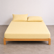 Tate Fitted Sheet in Yellow, fitted snugly over a mattress on a timber bed frame