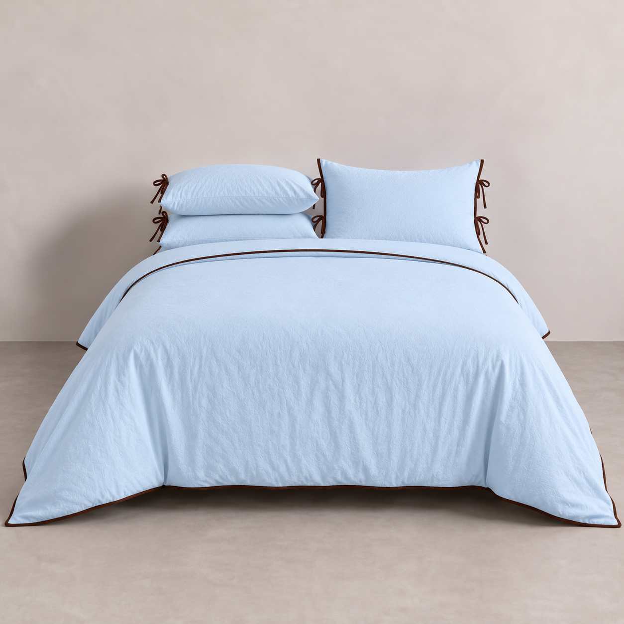 Wren Bedding Set in Powder Blue on a made bed, with contrast trim and tie details on the pillowcases