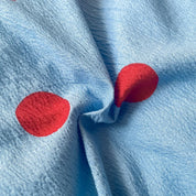 Close-up of the Ziggy Spot Bedding Set, cherry red spots on crinkled cotton blend fabric in soft blue