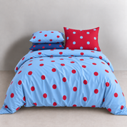 Ziggy Spot Bedding Set styled on a bed, cherry red spots on a soft blue quilt cover with matching pillowcases